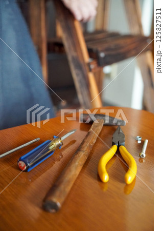 机に並べたDIY用の工具と職人の足元 125827511