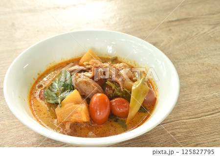 spicy boiled roasted duck meat with pineapple and tomato in coconut milk curry soup on bowl spicy boiled roasted duck meat with pineapple and tomato in coconut milk curry soup on bowl 125827795