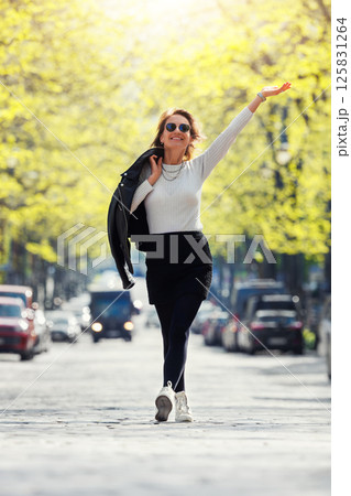 Dynamic scenic young adult pretty happy woman enjoy walk spring Magdeburg city Hegelstrasse Hegel street road green tree alley perspective background. Female person carefree portrait smiling outdoors 125831264