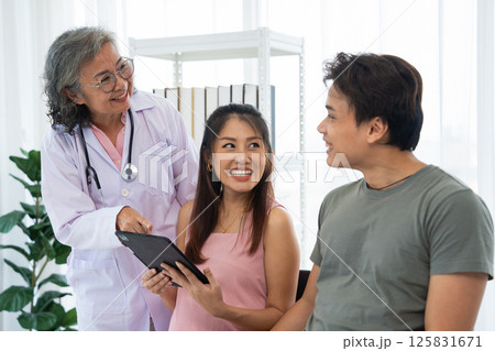 Senior female obstetrician consulting pregnant woman and her husband in medical clinic or hospital planning pregnancy. Visit to hospital, planning pregnancy, happy patients, trust and respect concept 125831671