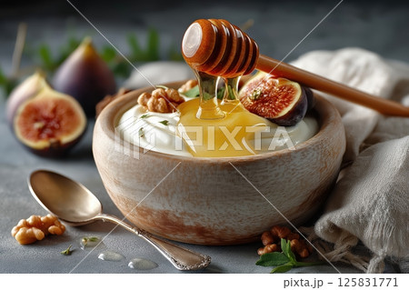 Thick Greek Yogurt with Honey Drizzle, Fresh Figs, and Walnuts on Stone Surface 125831771