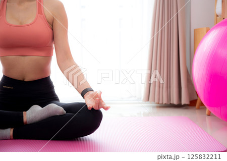 Young asian woman meditation sitting on mat in serene and tranquility with yoga posture lotus. 125832211