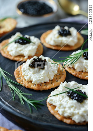 Gourmet Cracker Appetizer with Black Caviar and Cream Cheese on Elegant Plate 125833513