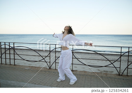 White-Clothed Girl Dances on Street Beside the Sea White-Clothed Girl Dances on Street Beside the Sea 125834261