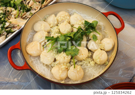 close up of homemade Chinese steamed scallop and Cellophane noodles with garlic and parsley as toppings in a pot close up of homemade Chinese steamed scallop and Cellophane noodles with garlic and parsley as toppings in a pot 125834262