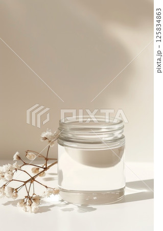 Natural Skincare Cream Jar with White Blossoms on Neutral Background Natural Skincare Cream Jar with White Blossoms on Neutral Background 125834863