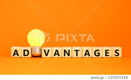 Advantages symbol. Concept word Advantages on beautiful wooden blocks. Beautiful orange table orange background. Yellow light bulb. Business advantages concept. Copy space. 125835148