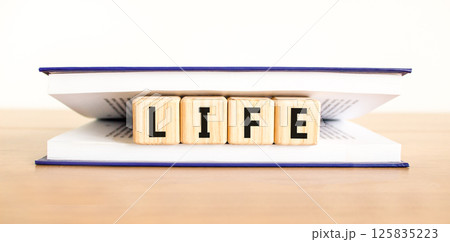 Life symbol. Concept word Life on beautiful wooden blocks in book. Beautiful wooden table white background. Business, lifestyle, support and life concept. Copy space. 125835223