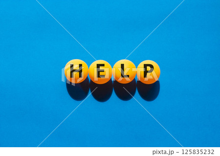 Help symbol. Concept word Help on beautiful yellow ping pong balls. Beautiful blue table blue background. Business, lifestyle, support and help concept. Copy space. 125835232