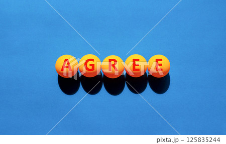 Agree symbol. Concept word Agree on beautiful yellow tennis ping pong balls. Beautiful wooden table wooden background. Business agree concept. Copy space. Agree symbol. Concept word Agree on beautiful yellow tennis ping pong balls. Beautiful wooden table wooden background. Business agree concept. Copy space. 125835244