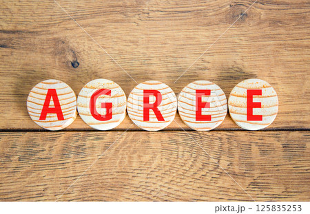 Agree symbol. Concept word Agree on beautiful wooden circles. Beautiful wooden table wooden background. Business agree concept. Copy space. Agree symbol. Concept word Agree on beautiful wooden circles. Beautiful wooden table wooden background. Business agree concept. Copy space. 125835253