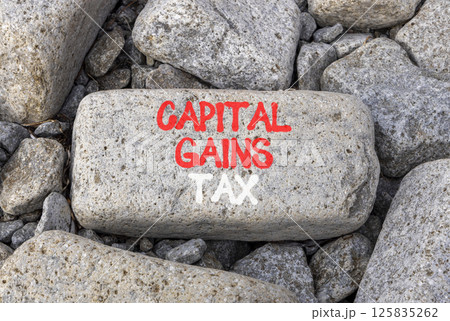 Capital gains tax symbol. Concept words Capital gains tax on beautiful grey stone. Beautiful grey mountain stone background. Business and capital gains tax concept. Copy space. 125835262