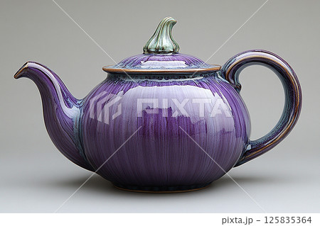 Ceramic teapot in shape of a purple eggplant in a classic style on a white background. 125835364