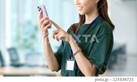 スマートフォンを使う笑顔の女性・ビジネスウーマン スマートフォンを使う笑顔の女性・ビジネスウーマン 125836723