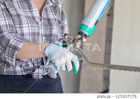 Person cleaning glue gun with a utility knife . 125837179