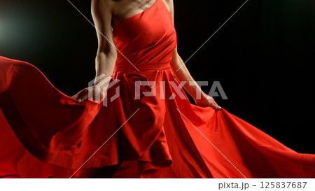 Brunette Woman in Ruby Red Dress Dancing Against a Black Background , Freeze Motion 125837687