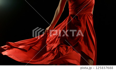Brunette Woman in Ruby Red Dress Dancing Against a Black Background , Freeze Motion 125837688