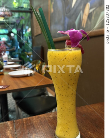 vertical photos Tropical mango smoothie Mango juice in a glass and mango fruit on wooden background. 125837882
