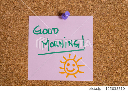 Pink sticky note wishing good morning on cork board 125838210