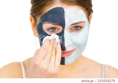 Girl remove black white mud mask from face Girl remove black white mud mask from face 125838279