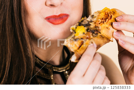 Woman eating hot pizza slice 125838333