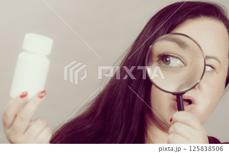 Woman investigating ingredients of medicines 125838506