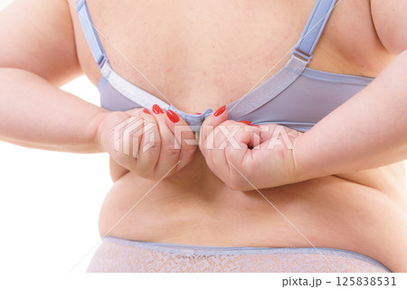 Woman back view putting on her bra lingerie. 125838531