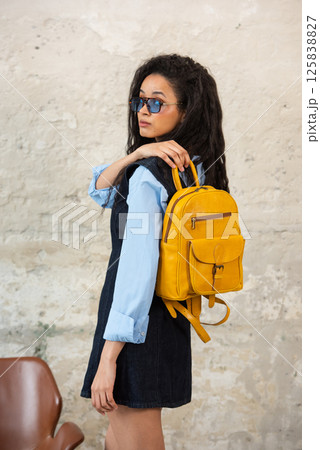 A Chic Outfit Featuring a Bright yellow Backpack Paired with Stylish and Trendy Dress and Blue Shirt A Chic Outfit Featuring a Bright yellow Backpack Paired with Stylish and Trendy Dress and Blue Shirt 125838827