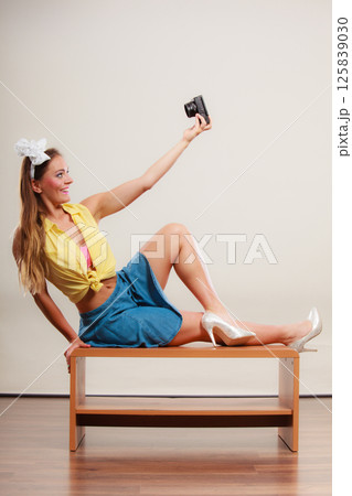 Pin up girl woman taking photo with camera. Pin up girl woman taking photo with camera. 125839030