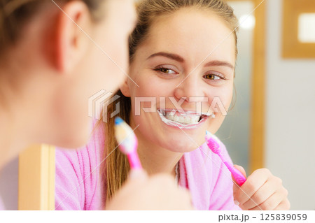 Woman brushing cleaning teeth in bathroom Woman brushing cleaning teeth in bathroom 125839059
