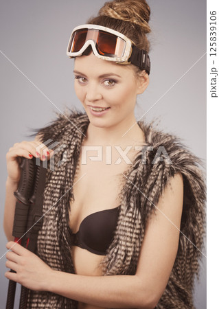 Sexy woman holding ski poles Sexy woman holding ski poles 125839106