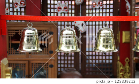 Golden Bells Hanging on Red Frame with Wooden Background in Traditional Setting Golden Bells Hanging on Red Frame with Wooden Background in Traditional Setting 125839212
