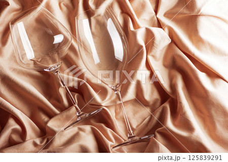 Two goblets on beige satin background. Top view Two goblets on beige satin background. Top view 125839291
