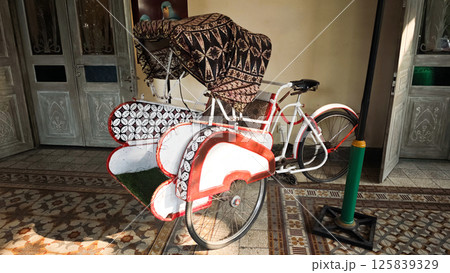 Traditional Becak Tricycle Adorned with Batik Patterns in an Indonesian Cultural Setting Traditional Becak Tricycle Adorned with Batik Patterns in an Indonesian Cultural Setting 125839329
