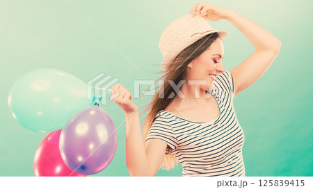 Happy girl playing with colorful balloons. 125839415
