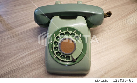 Vintage Green Rotary Dial Telephone or phone on Wooden Surface in Classic Design Vintage Green Rotary Dial Telephone or phone on Wooden Surface in Classic Design 125839460