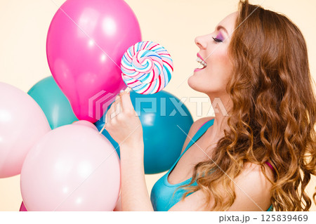 Woman with colorful balloons and lollipop Woman with colorful balloons and lollipop 125839469
