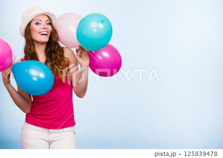 Woman playing with many colorful balloons Woman playing with many colorful balloons 125839478