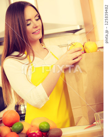 Woman housewife in kitchen with many fruits 125839482