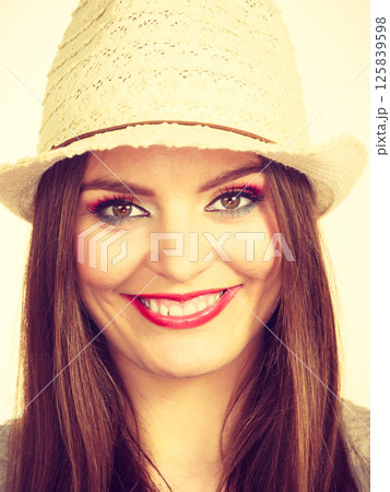 Happy flirty woman wearing sun hat 125839598