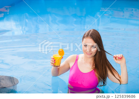 Girl with cocktail drink relaxing at swimming pool Girl with cocktail drink relaxing at swimming pool 125839686