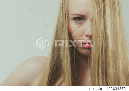 Sad girl covers her face with long hair Sad girl covers her face with long hair 125839775