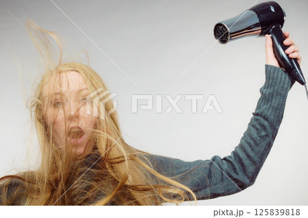 Woman styling her long hair 125839818