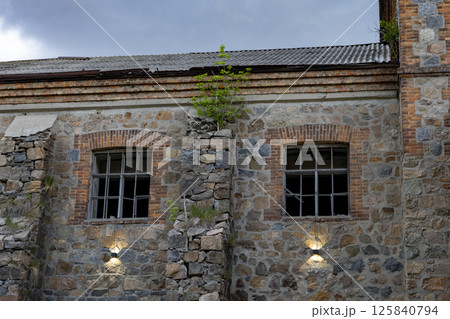 an old brick building that looks like a castle against a backdrop of storm clouds 125840794