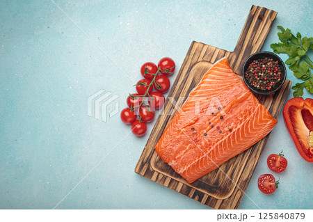 Fresh raw salmon fillet with cooking ingredients on wooden board top view on light blue background, space for text Fresh raw salmon fillet with cooking ingredients on wooden board top view on light blue background, space for text 125840879
