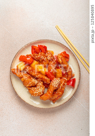 Asian sweet and sour chicken with pineapple and bell peppers on a plate with chopsticks top view Asian sweet and sour chicken with pineapple and bell peppers on a plate with chopsticks top view 125840895