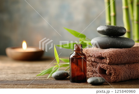 Relaxation Essentials With Stones, Aromatherapy Oil, and Soft Towels in a Serene Setting 125840960