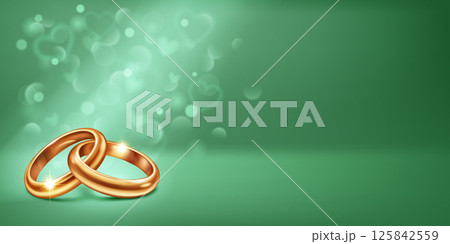 Two intertwined gold wedding rings and small hearts on green. Two intertwined gold wedding rings and small hearts on green. 125842559