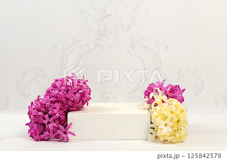 Empty product podium and fresh live hyacinths, abstract beautiful flower arrangement. Stage for business concept. Minimal modern aesthetic and elegant beauty concept, flower banner. Empty product podium and fresh live hyacinths, abstract beautiful flower arrangement. Stage for business concept. Minimal modern aesthetic and elegant beauty concept, flower banner. 125842578