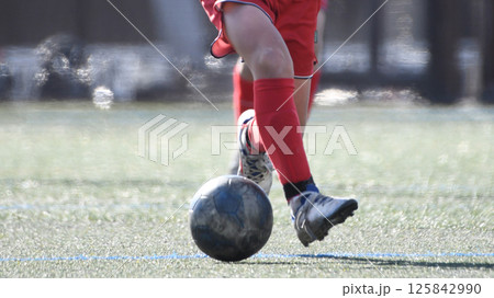 ドリブルするサッカー選手 125842990